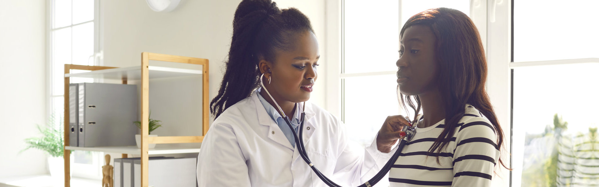 a female doctor checking heart of a female child